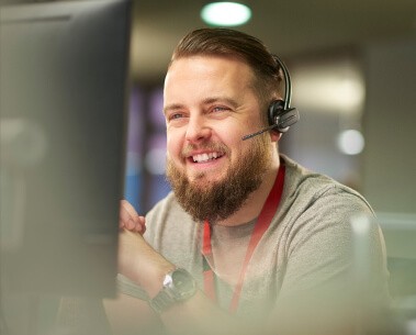 customer support employee is talking to a customer while looking at a computer