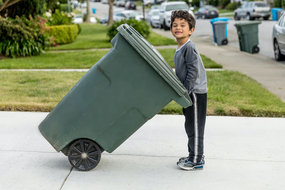 Boy is holdin a trash can